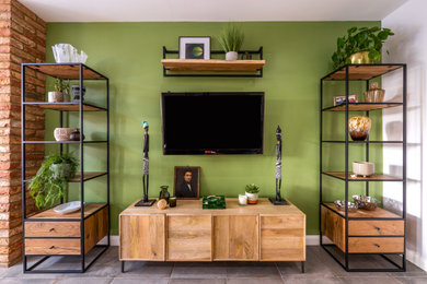Modelo de salón urbano de tamaño medio con paredes verdes, suelo de baldosas de porcelana, televisor colgado en la pared y suelo gris