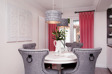 Cette image montre une salle à manger ouverte sur la cuisine design avec un mur beige, un sol en contreplaqué et un sol gris.