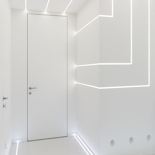 Пример оригинального дизайна интерьера: маленькая узкая прихожая в современном стиле с белыми стенами, полом из керамогранита и белым полом