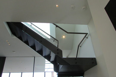 Photo of a large modern wood spiral staircase in Boston with glass risers.