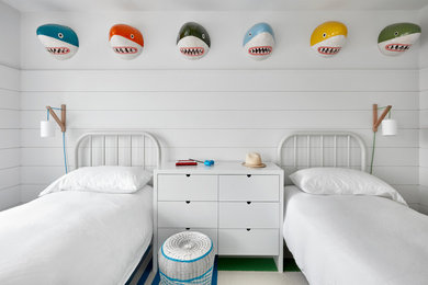 Design ideas for a beach style gender-neutral kids' bedroom for kids 4-10 years old in New York with white walls, carpet and multi-coloured floor.