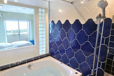 横浜にある中くらいなビーチスタイルのおしゃれなマスターバスルーム (ドロップイン型浴槽、洗い場付きシャワー、青いタイル、磁器タイル) の写真
