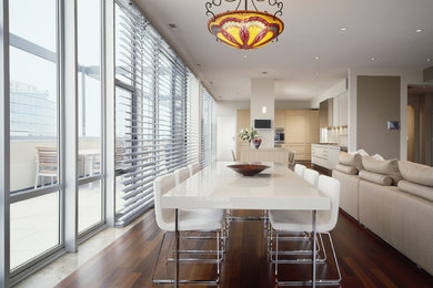 This is an example of a mid-sized contemporary open plan dining in Chicago with white walls, dark hardwood floors, no fireplace and brown floor.