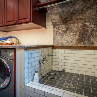 シャーロットの巨大なラスティックスタイルのおしゃれな家事室 (レイズドパネル扉のキャビネット、赤いキャビネット、ラミネートカウンター、ベージュの壁、セラミックタイルの床、左右配置の洗濯機・乾燥機) の写真