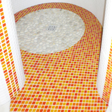 die bodengleiche Dusche mit Muster aus Mosaikfliesen und Kieselsteinen