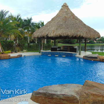 Tiki Hut with bar Area for Custom Pool with Rock Waterfall and Wet Edge Spa in D