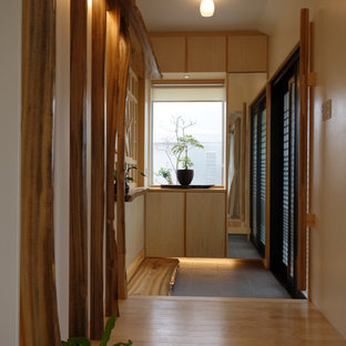 他の地域のアジアンスタイルのおしゃれな玄関 (ベージュの壁、無垢フローリング、茶色い床) の写真