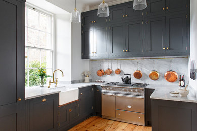 Country u-shaped enclosed kitchen in Edinburgh with a belfast sink, shaker cabinets, grey cabinets, white splashback, stainless steel appliances, medium hardwood flooring and no island.