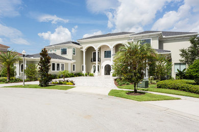 Design ideas for an expansive transitional two-storey stucco beige exterior in Orlando.