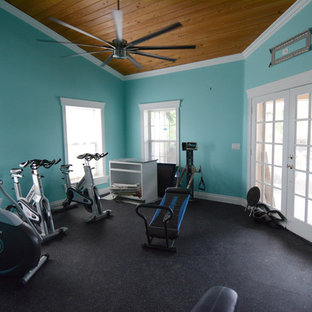 マイアミの大きいトランジショナルスタイルのおしゃれな多目的ジム (青い壁、黒い床) の写真