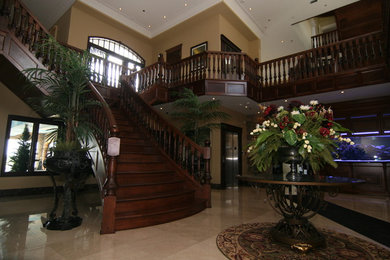 Large traditional wood curved staircase in Montreal with wood risers.