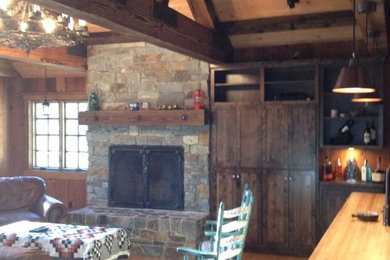 Mid-sized mountain style open concept light wood floor family room photo in Other with a standard fireplace, a stone fireplace and brown walls
