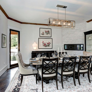Idée de décoration pour une salle à manger ouverte sur le salon tradition de taille moyenne avec un mur blanc, un sol en bois foncé, une cheminée ribbon et un manteau de cheminée en pierre.