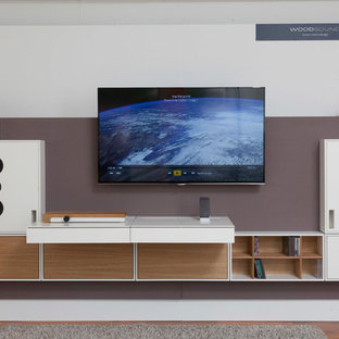 Large trendy enclosed dark wood floor and brown floor home theater photo in Stuttgart with white walls and a wall-mounted tv