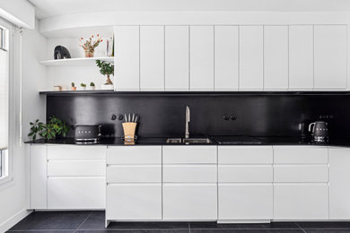 Idées déco pour une cuisine encastrable contemporaine en L fermée et de taille moyenne avec un évier intégré, des portes de placard blanches, une crédence noire, aucun îlot, un sol noir, plan de travail noir et un placard à porte plane.