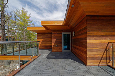 Expansive modern side yard deck in Toronto with a roof extension.