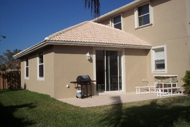 Example of a large classic beige two-story stucco exterior home design in Miami with a tile roof