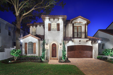 This is an example of a mid-sized mediterranean two-storey stucco white exterior in Orlando.