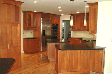 Open concept kitchen - mid-sized contemporary u-shaped medium tone wood floor and brown floor open concept kitchen idea in Orlando with an undermount sink, shaker cabinets, medium tone wood cabinets, granite countertops, stainless steel appliances and an island