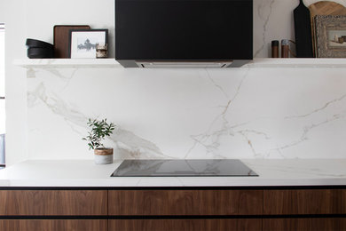 Inspiration for a small modern l-shaped light wood floor and brown floor eat-in kitchen remodel in Salt Lake City with an undermount sink, flat-panel cabinets, medium tone wood cabinets, quartz countertops, white backsplash, quartz backsplash, stainless steel appliances, an island and white countertops