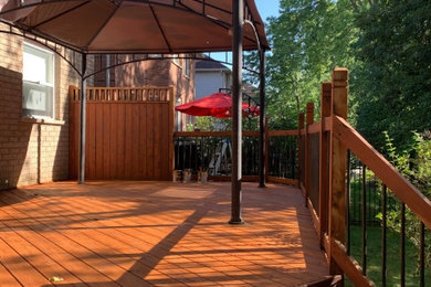 Deck - small modern backyard ground level mixed material railing deck idea in Toronto