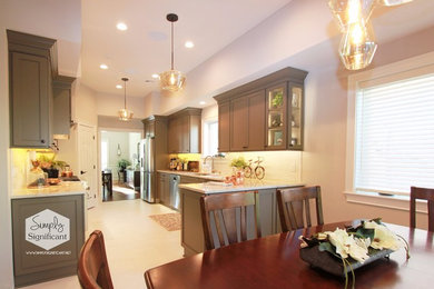 Porcelain tile and white floor kitchen photo in New Orleans with a drop-in sink, recessed-panel cabinets, gray cabinets, granite countertops, white backsplash, subway tile backsplash, stainless steel appliances and an island