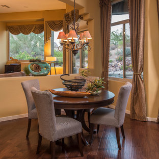 Offenes, Kleines Mediterranes Esszimmer ohne Kamin mit gelber Wandfarbe und braunem Holzboden in Phoenix