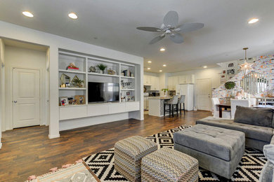 Inspiration for a mid-sized contemporary open concept laminate floor and brown floor family room remodel in Las Vegas with white walls, no fireplace and a tv stand