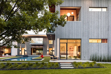 Photo of an expansive contemporary three-storey grey house exterior in Dallas with a flat roof.
