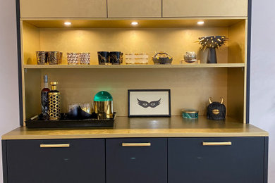 This is an example of a modern single-wall dry bar in New York with flat-panel cabinets and black cabinets.