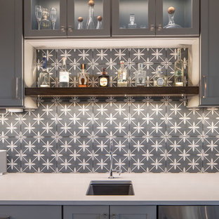 インディアナポリスの中サイズのトランジショナルスタイルのおしゃれなウェットバー (アンダーカウンターシンク、シェーカースタイル扉のキャビネット、グレーのキャビネット、グレーのキッチンパネル、セメントタイルのキッチンパネル、無垢フローリング、茶色い床、白いキッチンカウンター) の写真