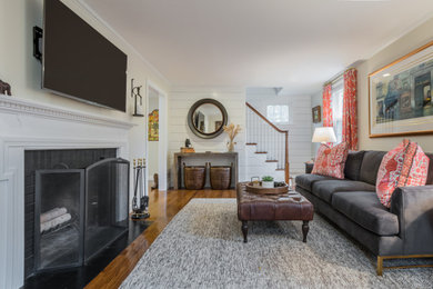 Medium sized classic formal enclosed living room in Boston with white walls, medium hardwood flooring, a standard fireplace, a wooden fireplace surround, a wall mounted tv and tongue and groove walls.