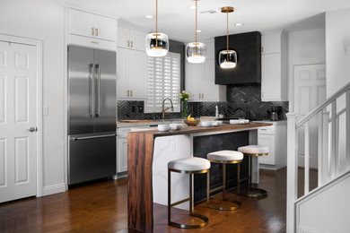 Mid-sized minimalist l-shaped medium tone wood floor and brown floor eat-in kitchen photo in Las Vegas with an undermount sink, shaker cabinets, white cabinets, solid surface countertops, black backsplash, porcelain backsplash, stainless steel appliances and an island