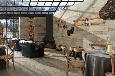 Large mountain style light wood floor kitchen/dining room combo photo in Other with brown walls and a corner fireplace