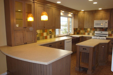 This is an example of a mid-sized arts and crafts u-shaped eat-in kitchen in Chicago with a farmhouse sink, recessed-panel cabinets, light wood cabinets, quartz benchtops, beige splashback, ceramic splashback, stainless steel appliances, ceramic floors, with island and beige floor.