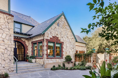 Mid-sized elegant two-story stone exterior home photo in Austin with a shingle roof and a gray roof