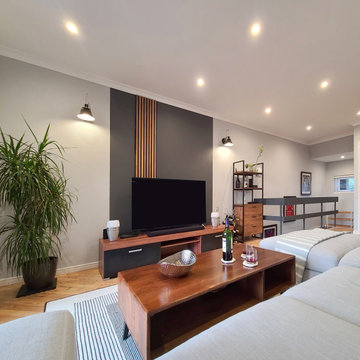 Living Room Oasis: Black Accent Wall, Wood Paneling, Sleek Grey Sofa - Interior 