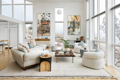 Example of a mid-sized trendy formal and open concept light wood floor and brown floor living room design in Denver with white walls