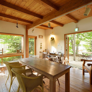 Esempio di una sala da pranzo etnica con pareti bianche, pavimento in legno massello medio e pavimento marrone