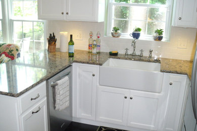 Eat-in kitchen - small transitional u-shaped dark wood floor eat-in kitchen idea in St Louis with a farmhouse sink, flat-panel cabinets, white cabinets, quartz countertops, white backsplash, ceramic backsplash, stainless steel appliances and a peninsula