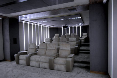 Пример оригинального дизайна: изолированный домашний кинотеатр в современном стиле с бежевыми стенами, ковровым покрытием, проектором и коричневым полом