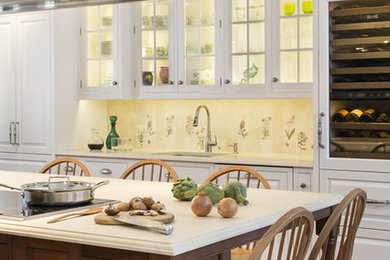 Large elegant galley medium tone wood floor and brown floor kitchen photo in Jacksonville with raised-panel cabinets, white cabinets, multicolored backsplash, stainless steel appliances, an island, limestone countertops, porcelain backsplash, an undermount sink and beige countertops