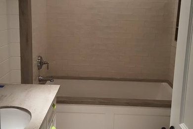 Mid-sized elegant 3/4 white tile and subway tile mosaic tile floor and brown floor bathroom photo in New York with recessed-panel cabinets, white cabinets and an undermount sink