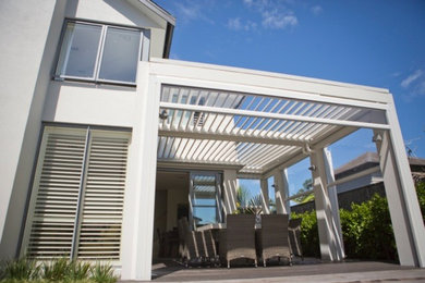 Photo of a contemporary verandah in Auckland with a pergola.