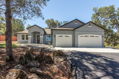 Mid-sized transitional gray one-story stucco exterior home idea in Sacramento with a shingle roof