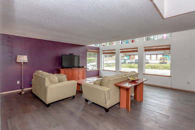 Inspiration for a medium tone wood floor and brown floor living room remodel in Seattle with purple walls and no fireplace
