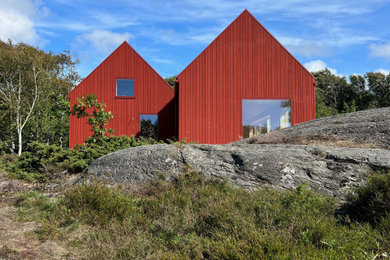 Design ideas for a red scandinavian house exterior in Stockholm with wood cladding.