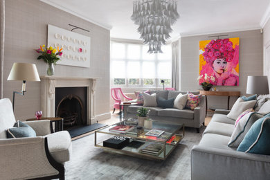 Photo of a classic living room in London with grey walls, medium hardwood flooring, a standard fireplace, brown floors and wallpapered walls.