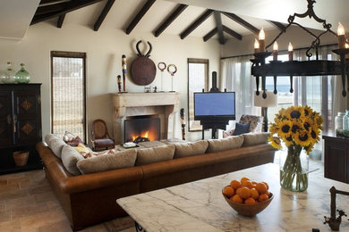 Large open concept living room in San Francisco with beige walls, terra-cotta floors, a standard fireplace, a stone fireplace surround, a freestanding tv and beige floor.