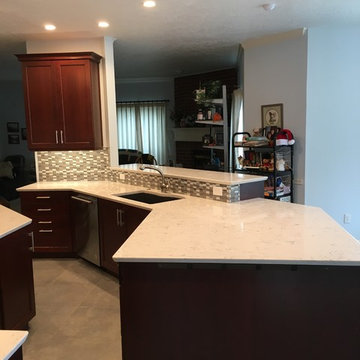 Bright kitchen with dark cabinets and white countertops, undermount sink
